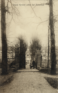 16020 Gezicht op het toegangshek en in de oprijlaan van het kerkhof (Zinzendorflaan z.n.) te Zeist uit het zuidwesten.